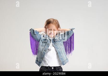 Little girl closed her ears with hands and does not want to listen anyone Stock Photo