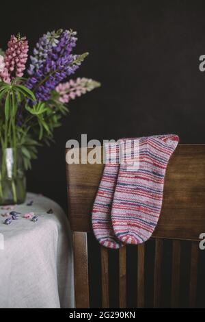 Hand knitting multicolored socks on a dark background. Concept for handmade and hygge slow life. Stock Photo