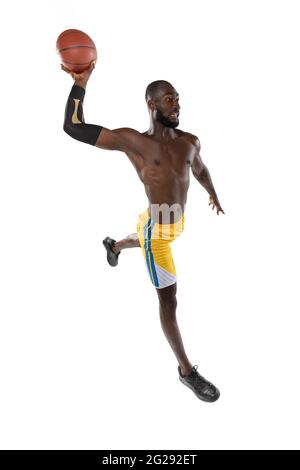 Full length portrait of a basketball player with a ball isolated on white studio background. advertising concept. Fit african american athlete jumping Stock Photo