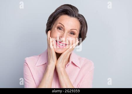 Close-up portrait of attractive cheerful pleased woman enjoying good mood isolated over gray pastel color background Stock Photo