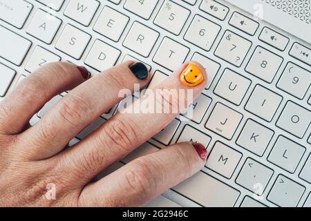 A young programmer works at a computer. Painted nails close-up. fashionable painted nails on a man's hand. Men's manicure Stock Photo