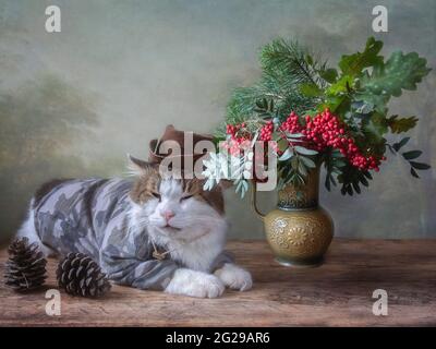 Funny cat in hunter hat and autumnal bouquet Stock Photo
