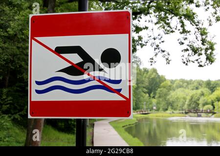 No swimming sign on background of summer lake. Beach holiday in city park Stock Photo