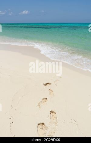 A deserted tropical beach with human footprints on the sand Stock Photo