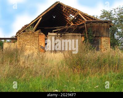 Abadoned barn ruin on the edge of the village, old dilapidated farmhouse Stock Photo