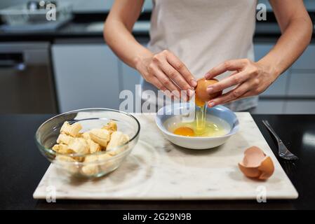 Woman opening an egg for a banana pancake recipe
