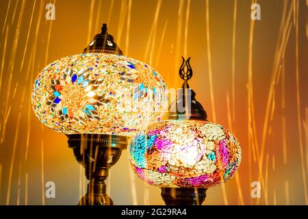 Illuminated Turkish Moroccan handmade stain glass lamps. Vibrant and colourful with unique light flare flashes, trails, streaks running through. Antiq Stock Photo