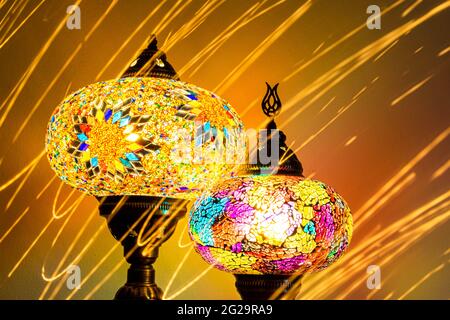 Illuminated Turkish Moroccan handmade stain glass lamps. Vibrant and colourful with unique light flare flashes, trails, streaks running through. Antiq Stock Photo