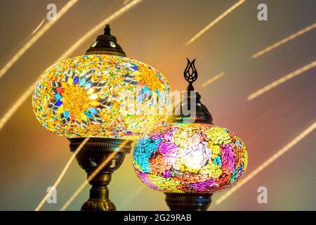 Illuminated Turkish Moroccan handmade stain glass lamps. Vibrant and colourful with unique light flare flashes, trails, streaks running through. Antiq Stock Photo