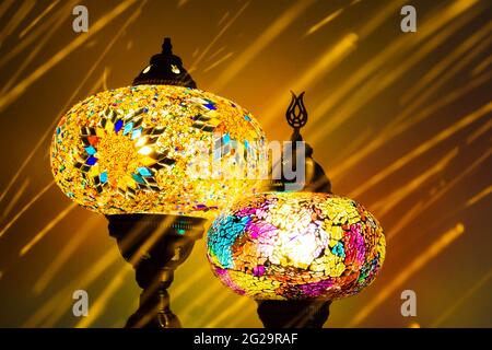 Illuminated Turkish Moroccan handmade stain glass lamps. Vibrant and colourful with unique light flare flashes, trails, streaks running through. Antiq Stock Photo