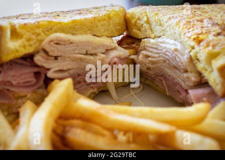 A monte cristo sandwich sits on a white plate at a diner.  Served with French fries. Stock Photo