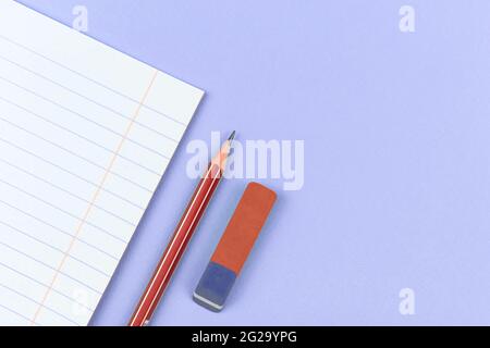 School notebook with pencil and eraser school composition backgorund on purple office table Stock Photo