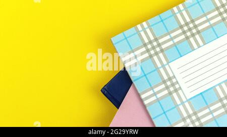 A lot of school diary on yellow bright table background, top view with copy space Stock Photo