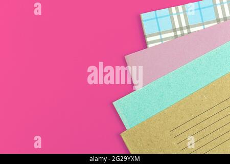 Many school notebooks on pink table offide desktop background, school concept flat lay background Stock Photo