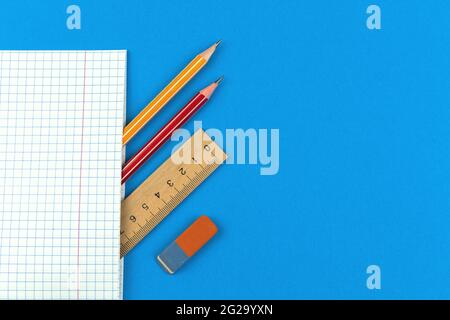 Prepare for the first school days concept composition, flat lay blue background with notebook, pencil, wooden ruler and eraser, copy space top view ph Stock Photo