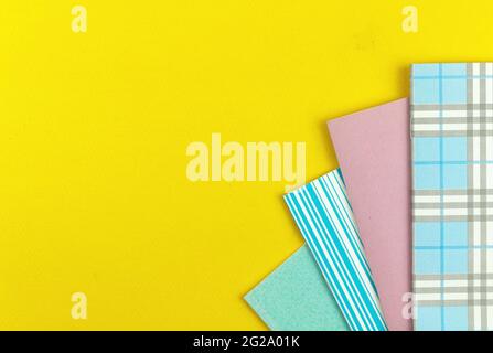 Ready to school composition background with school colorful notebooks on yellow table, top view Stock Photo