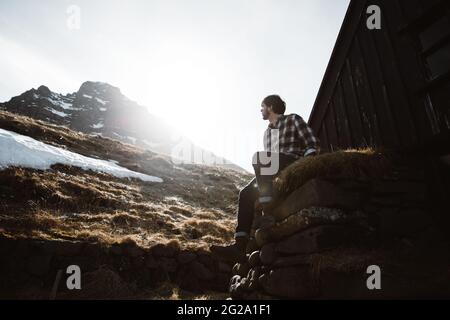Young man looking at mountain and sun Stock Photo