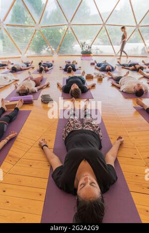 Yoga class in studio room,Group of people doing seated tree pose with ...