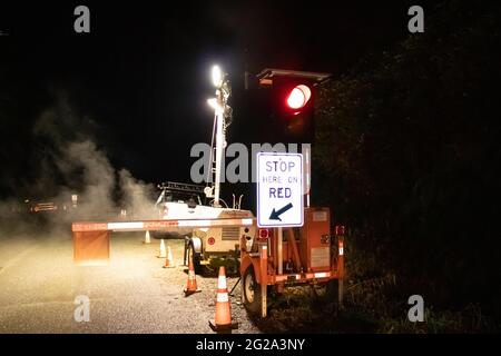 Kennedy Hill, Canada - December 11, 2020:View of sign Stop Here On Red due to A major upgrade to Highway 4 at Kennedy Hill northeast of the Tofino Stock Photo