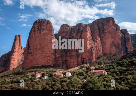 The Mallos de Riglos stand behind the village with the same name.  Impressive red rocks with vertical walls, very appreciated by climbers. Spain. Stock Photo