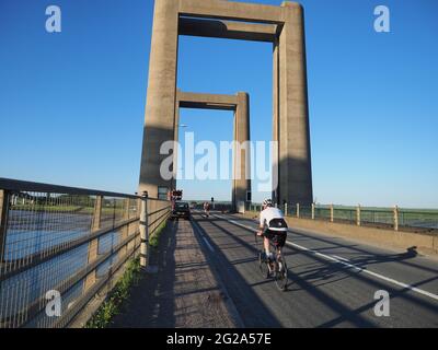 Iwade, Kent, UK. 9th June 2021. Wigmore Cycling Club organised a 10 mile time trial on the new 'Q10/45' course, which runs from Iwade to the Cowstead roundabout on the Isle of Sheppey. Amateur riders pass through the iconic Kingsferry Bridge landmark four times, as they attempt to complete the 10 mile course in the quickest time possible after being set off at intervals. Pictured: riders passing over the Kingsferry Bridge. Credit: James Bell/Alamy Live News Stock Photo