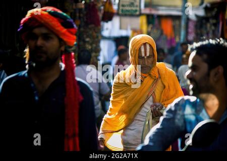 Pushkar, India - November 10, 2016: A hindu man with vishnu tilak on his forehead and orange ethnic wear walking in famous pushkar mela or fair in the Stock Photo