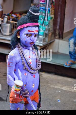 Pushkar, India - NOVEMBER 10, 2016: An unidentified boy dressed and disguised as hindu Lord Shiva with blue paint attends the Pushkar cattle fair in t Stock Photo