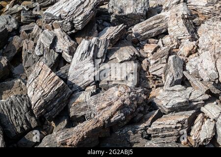 Aegean sea sharp big rocks shore close-up texture. Various rocky surface in sunny Greece near Athens Stock Photo