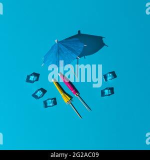 summer mockup with blue pastel colors. many beach or cocktail umbrellas and ice cubes at midday sun and hard shadows at the background for copy space Stock Photo