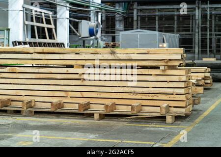 Stack of wooden boards in woodworking factory. Timber for construction industry. Stock Photo