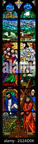 Stained-glass window depicting the Last Supper and Jesus carrying the cross. Above is the town of Erl in Tyrol with its church. Votivkirche. Stock Photo