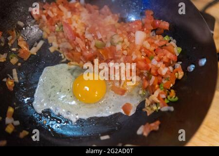 Top view of fried egg and pico de gallo in a frying pan Stock Photo