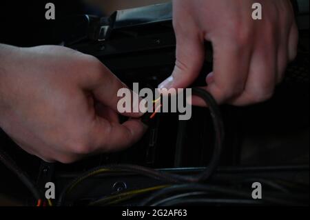 The computer technician connects the power cable to the hard drive. Stock Photo