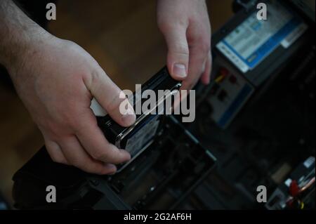 The computer technician installing the hard drive into the desktop computer case. Stock Photo