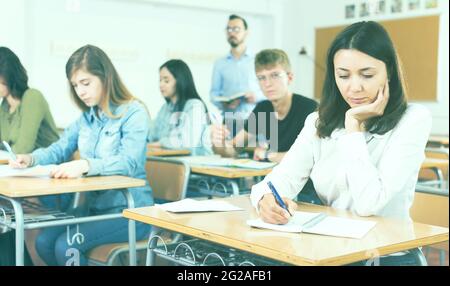 schoolgirl is sitting test and answer about task Stock Photo