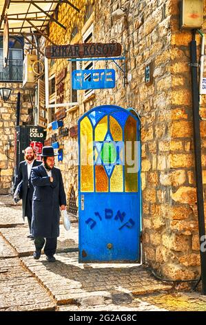Orthodox Jews walk along Safed Street, Galilee, Israel,Asia, Middle East Stock Photo