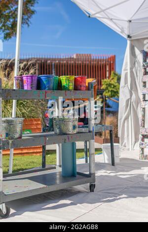 An artist colorful paint buckets on a cart. Stock Photo