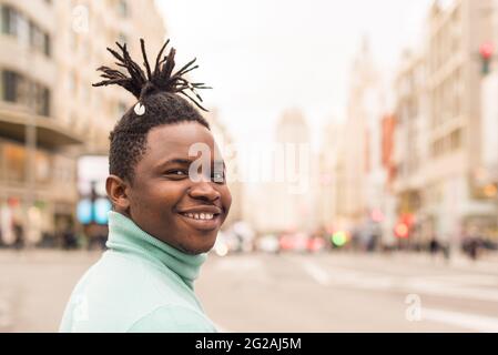 Young black man in the middle of the city, smiling. Stock Photo