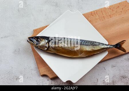Smoked mackerel on a white rectangular plate on a light gray background. Top view, flat lay Stock Photo