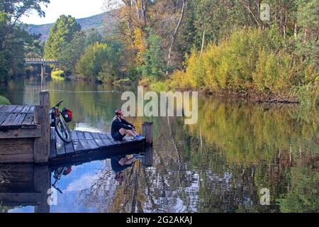 Cyclist by the Ovens River in Porepunkah Stock Photo