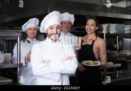 Chef in kitchen with staff Stock Photo
