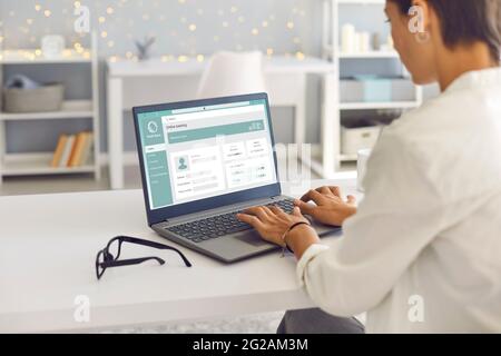 Woman using laptop computer, managing her bank account and transferring money online Stock Photo