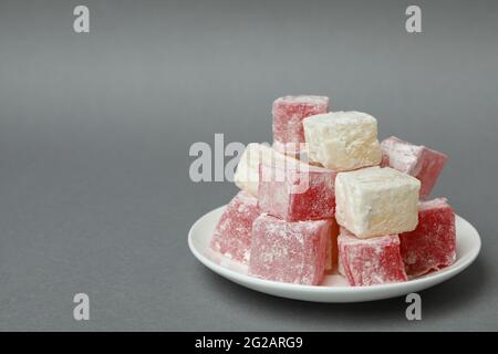 Plate with delicious turkish delight on gray background Stock Photo