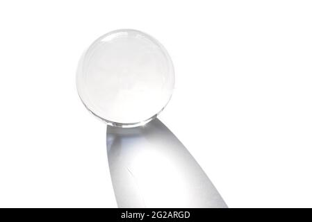 Glass globe ball isolated on white background. Globe ball as decoration of interior with shadow by sunlight Stock Photo