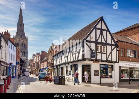 4 July 2019: Newark on Trent, Nottinghamshire, UK - Shopping in Middle Gate and Kirk Gate, with a view to the historic parish Church of St Mary Magdal Stock Photo