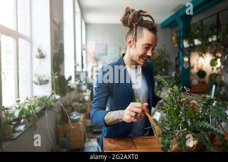 Handsome young man cleaning plant leaves with brush Stock Photo