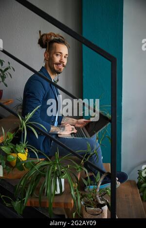 Joyful young man using notebook at home Stock Photo