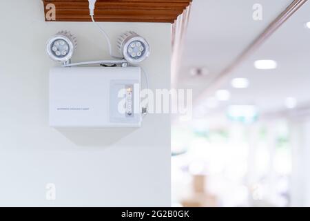 Automatic EMERGENCY LIGHT in hospital is charging and power pluging on the wall that ready to use when the power went out. Stock Photo