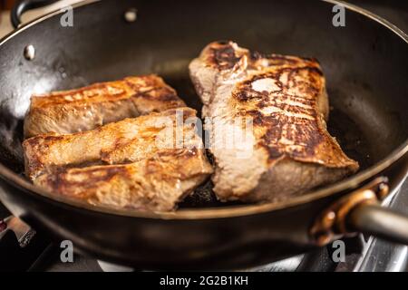 Finely roasted wild boar meat on a pan for a hunting dinner. Stock Photo