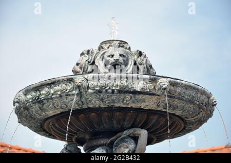 Ancient style fountain with lion heads on the top. Stock Photo